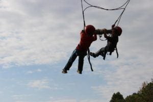 Two kids on a zip line course at YMCA Camp Willson