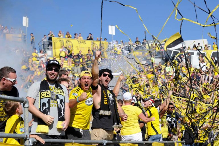 10 Most Fanatic Columbus Crew Bars In The City 4 Columbus Crew fans in yellow and black celebrating with confetti in the stands