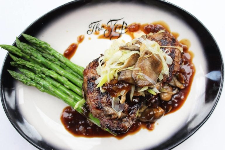 12 Incredible Fine Dining Restaurants In Columbus (2026) 2 Steak with mushrooms and asparagus on a signature plate at The Top Steak House
