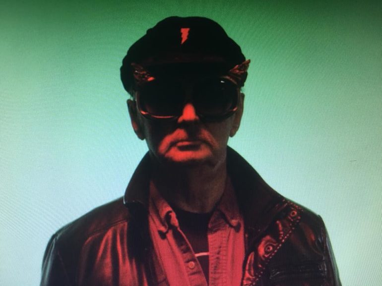 Just Who Is Fritz The Night Owl?? 5 Man wearing sunglasses and red shirt against teal background in stylized portrait.