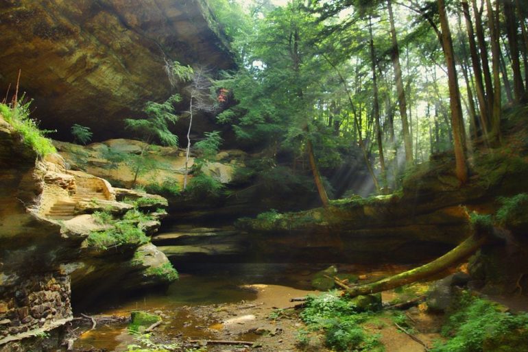 Explore These 12 Breathtaking Caves In The Buckeye State 4 Sunlight streams through trees over a rocky gorge at Old Man's Cave