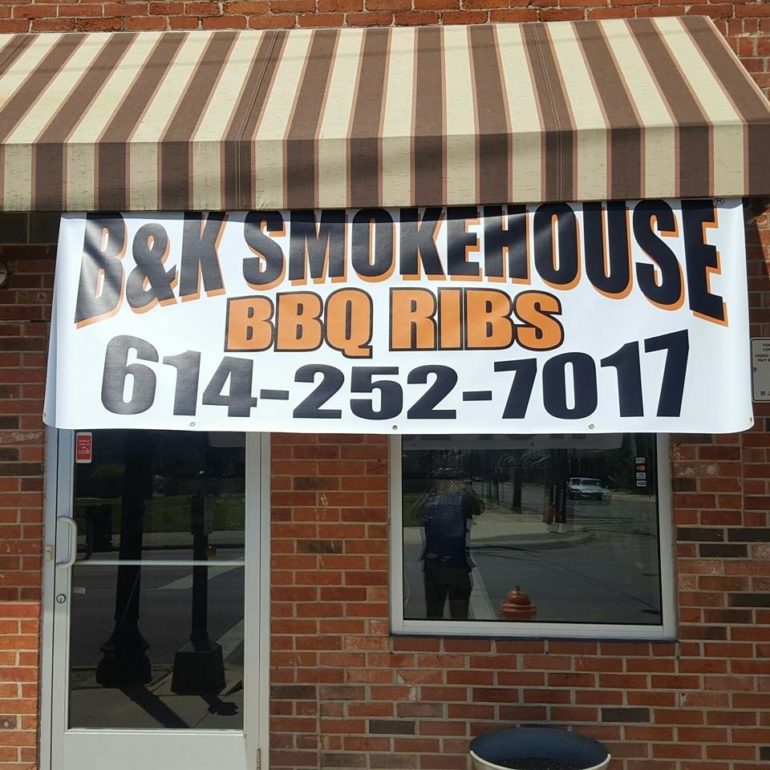 B&K Smokehouse BBQ Ribs storefront banner with phone number under a striped awning