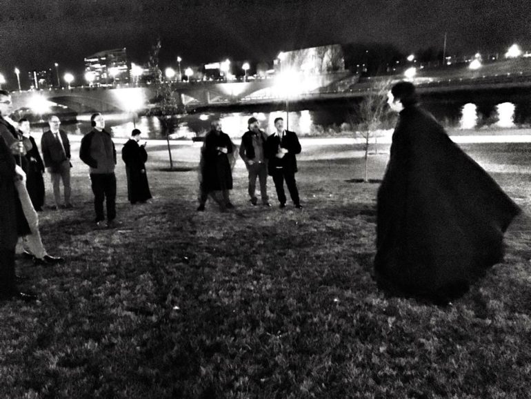 Spooky Columbus Ghost Tours Are Waiting For You, Including One That Will Give You A Serious Buzz 4 Cloaked figure leads tour group through riverside park at night in black and white