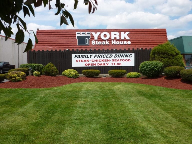 The Oldest Columbus Restaurants Have Been Open For Generations 6 York Steak House exterior sign with family priced dining announcement over landscaped hedges