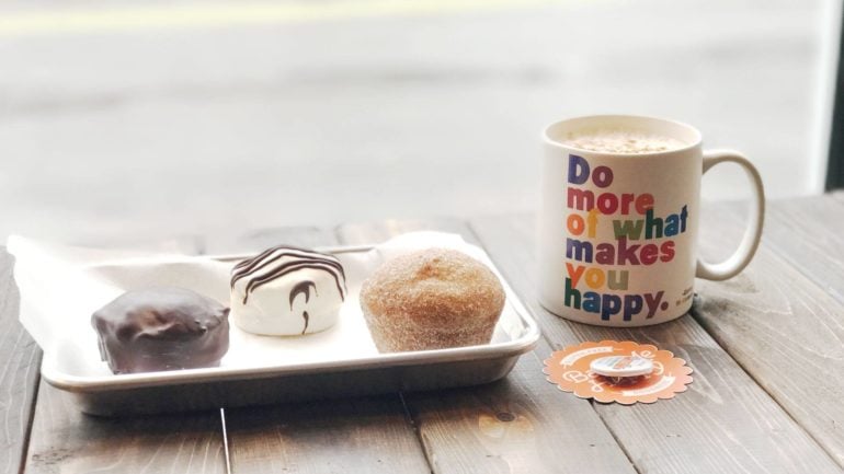 Local Restaurants Participate In Columbus Black Restaurant Week 4 Tray of three pastries beside a mug of coffee at Bake Me Happy