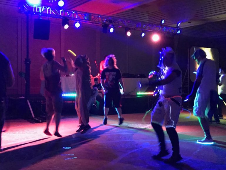 That Time I Went To A My Little Pony Rave In Worthington And Learned About Friendship... No Really 2 People dance under colorful stage lights with glow accessories at an indoor event