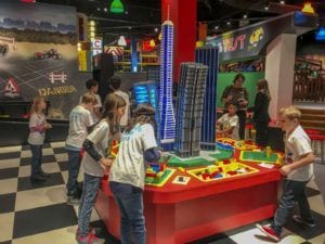 Children build a LEGO city skyline model at a hands-on table