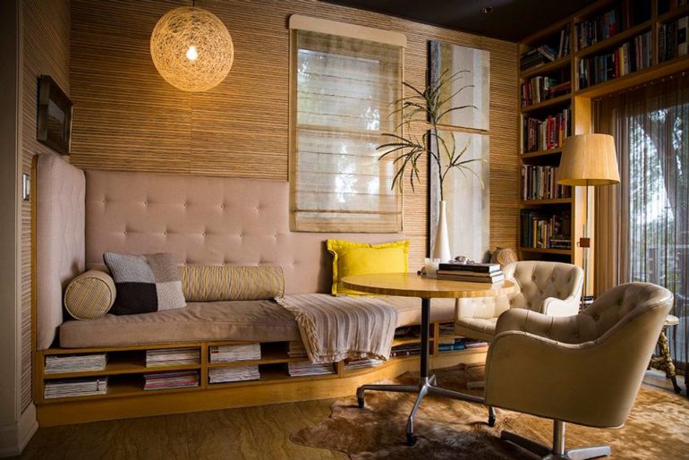 The Most Awesome Airbnbs in Ohio 1 Built-in daybed seating with bookshelves, round table and chairs by a textured wall