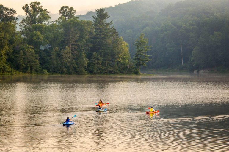 The Most Beautiful Lakes In Ohio 4 Kayakers paddling across misty Lake Hope surrounded by forested hills