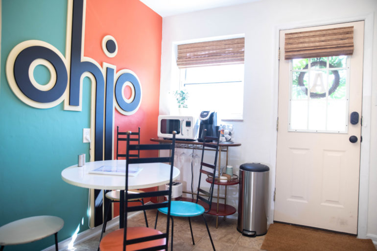 Kitchenette with a giant Ohio wall graphic, round table, chairs, and microwave stand