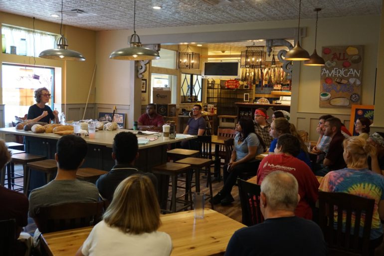 Katzinger's Will Open A New Delicatessen In Dublin Next Week 3 Woman speaks at a deli counter while seated customers listen in a casual restaurant