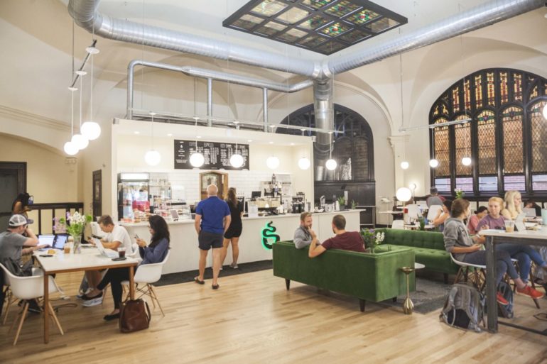 Stauf's Coffee Roasters Wants To Take You To Church In Their New Neil Ave. Spot 6 Interior of Stauf's Coffee Roasters with exposed ductwork, stained glass windows, and a green sofa