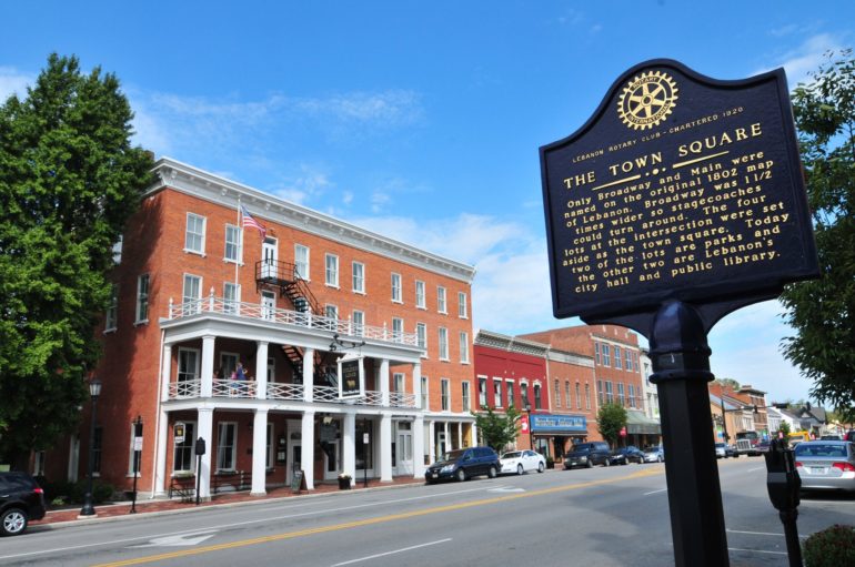 The Oldest Restaurant In Ohio Has Served 12 Presidents Over The Course Of Two Centuries 2 Historic brick buildings line a downtown street with a Rotary Club historical marker sign.
