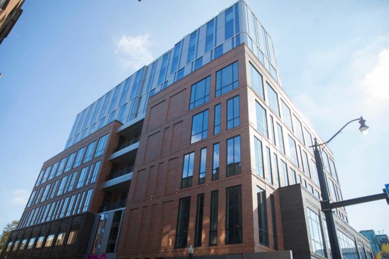 Moxy hotel building with red brick lower levels and glass upper floors