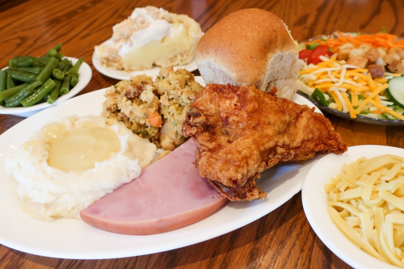 plate with mashed potatoes, chicken, ham, rolls, stuffing, and more