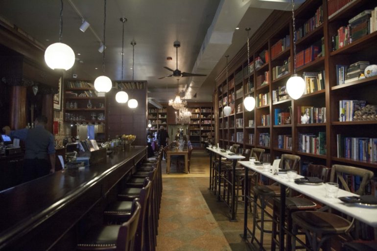 Bar and bookshelf-lined dining room interior at Asterisk Supper Club