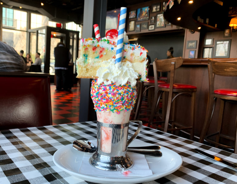 Burlesque And Burgers - Ivan Kane's Forty Deuce Is Officially Open At Easton 15 Milkshake topped with cake slice, sprinkles, and whipped cream at Ivan Kane's Forty Deuce