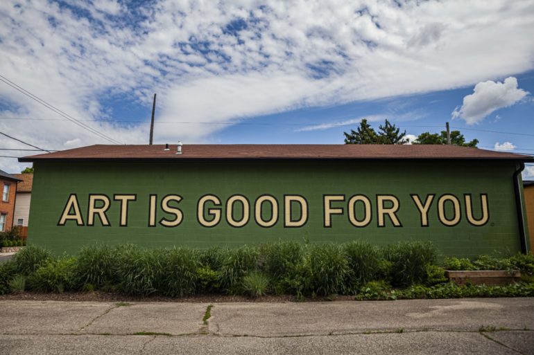 Art Is Good For You mural painted on green building exterior in Columbus