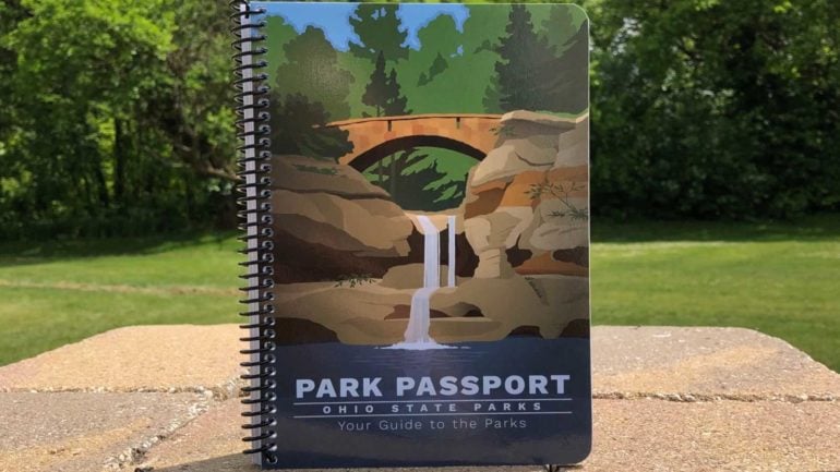 Explore Ohio's Incredible Parks With The Ohio State Parks Passport 18 Ohio State Parks Passport booklet displayed outdoors on a rock