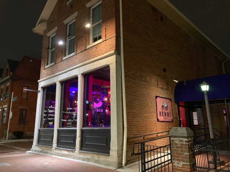 Běndì Wok N' Bar's corner storefront glowing purple at night in German Village