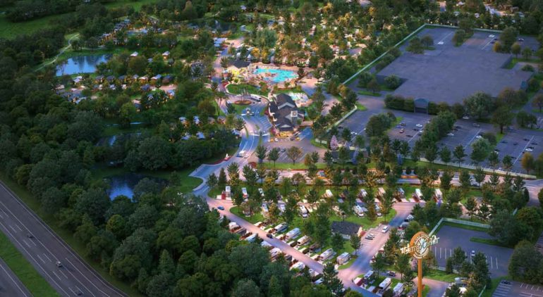 Aerial view of a resort campground with swimming pool, RV sites, and recreational facilities surrounded by forest.
