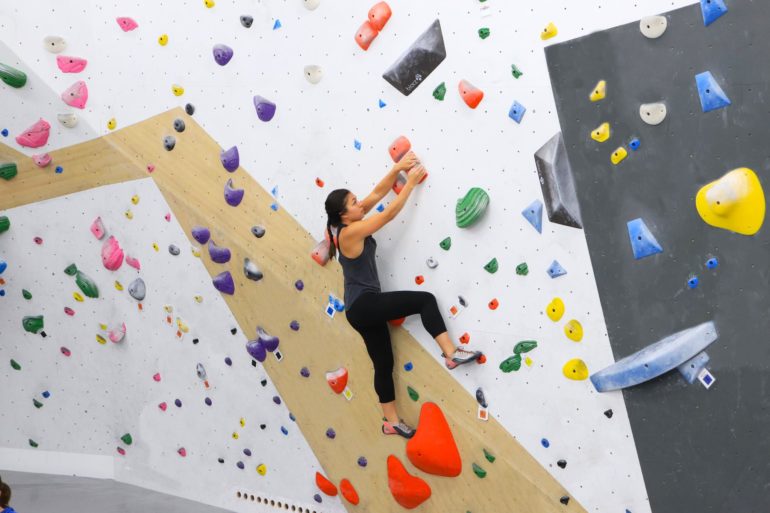 Where To Go Rock Climbing In Columbus 2 Climber on a colorful indoor bouldering wall at Chambers Purely Boulders