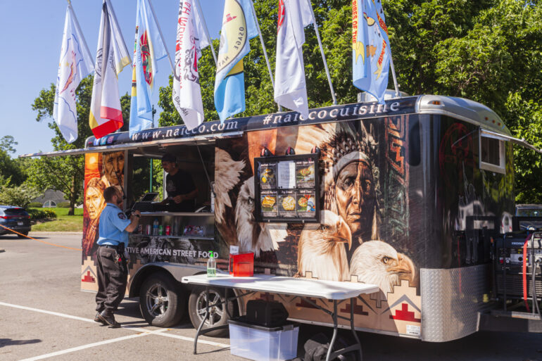 Native American-themed food truck with eagle and indigenous imagery displays at outdoor event.