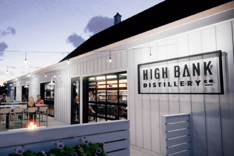 High Bank Distillery To Open A Second Location In Gahanna 11 Modern distillery building with white metal siding and illuminated signage at dusk.
