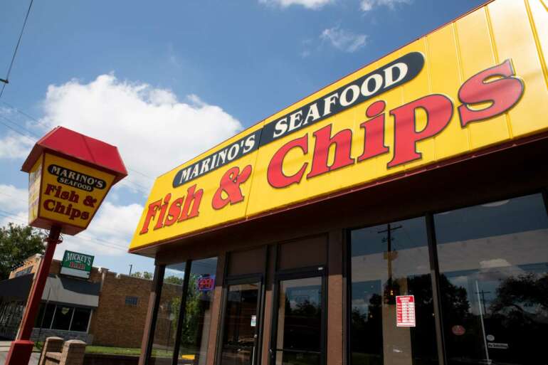 Marino's Seafood Fish & Chips storefront sign against blue sky