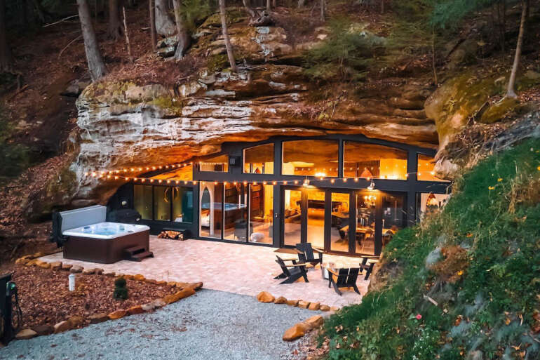 Cave House at Dunlap Hollow tucked under a rock overhang at dusk