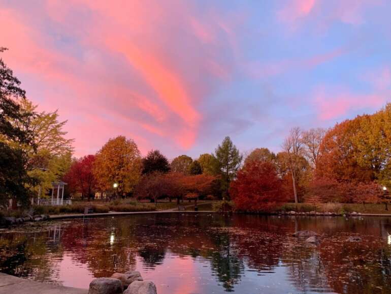 The Best Places To Watch The Sunrise In Columbus, Ohio 2 Goodale Park pond reflecting pink sunrise sky with autumn trees