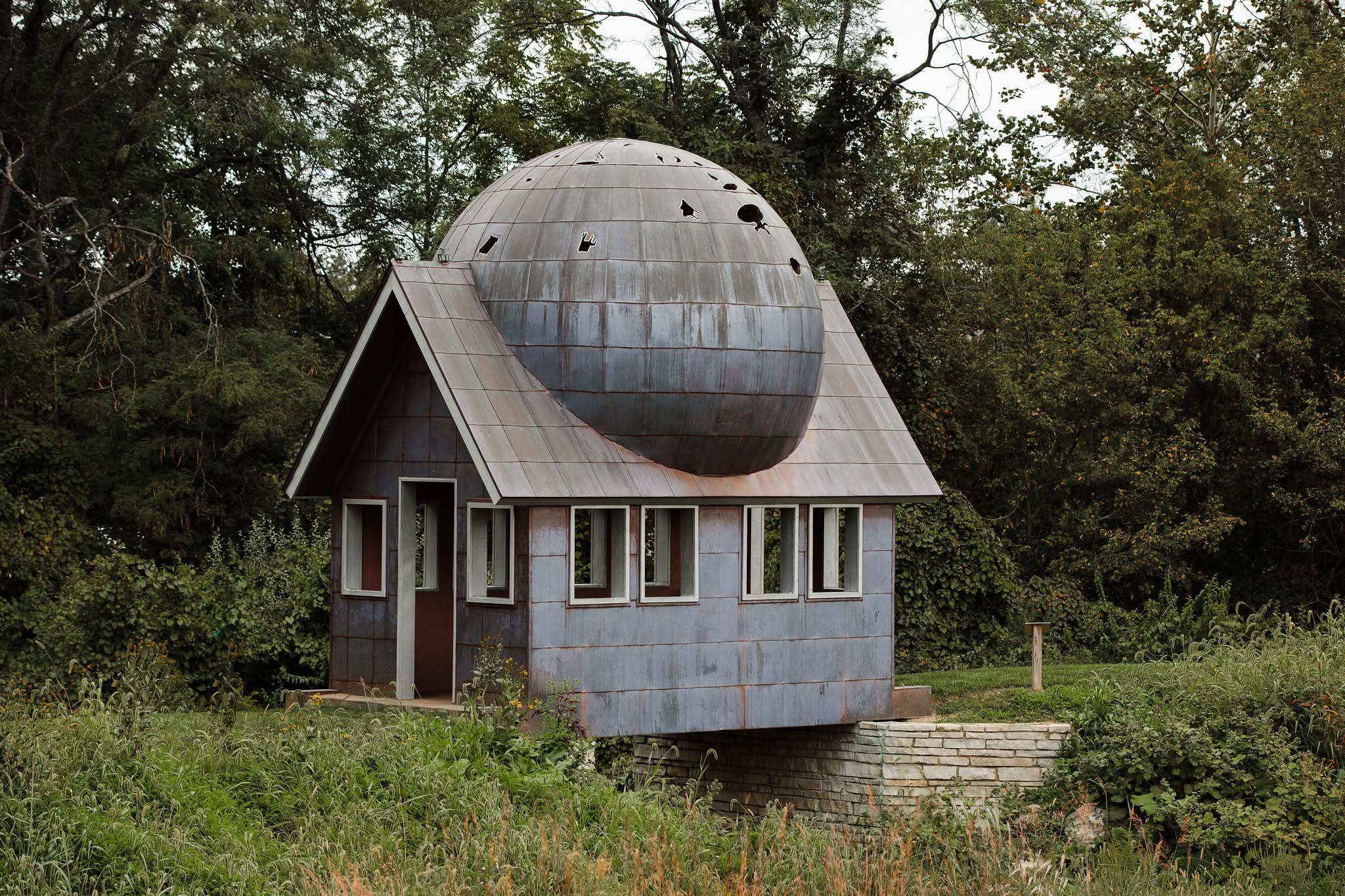 19 Of The Weirdest Roadside Attractions Around Central Ohio 15 cabin-like art installation with sphere on roof