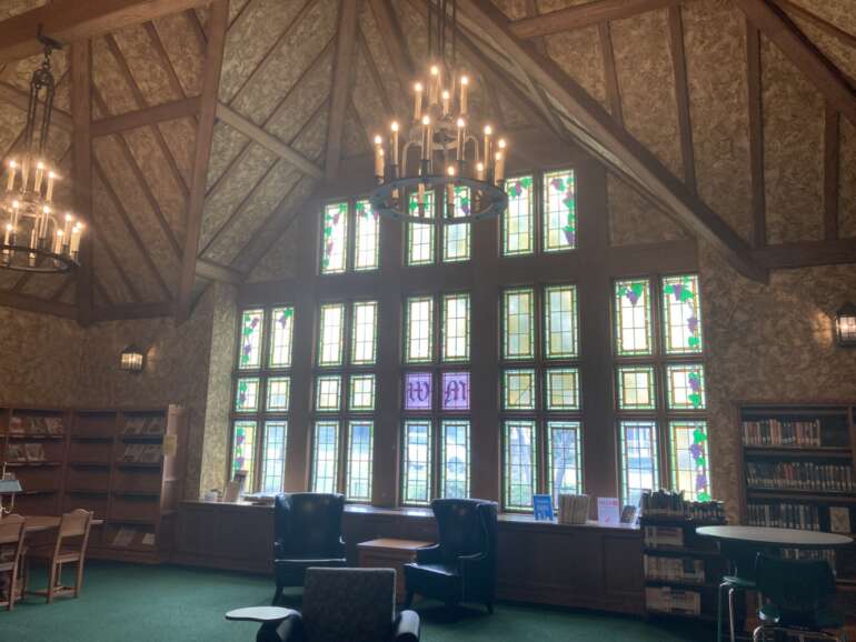 Leather chairs beneath tall stained glass windows in the Wagnalls Memorial Library reading room