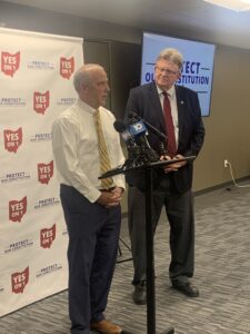 Ohio’s Issue 1 Goes Down To Defeat 2 Two men at a press conference behind Yes On 1 Protect Our Constitution signage