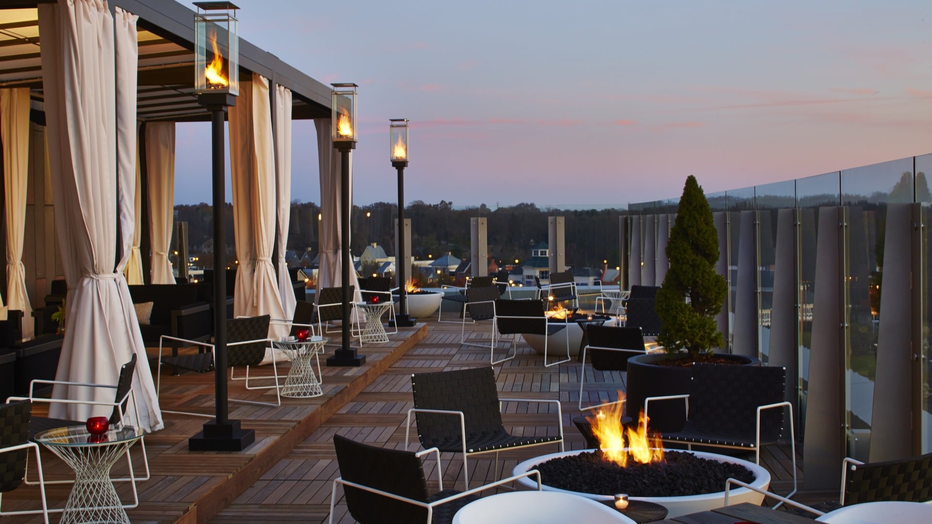 Vaso Rooftop Lounge terrace at dusk with fire bowls, cabanas and the Dublin treeline, Bridge Park, Dublin, Ohio