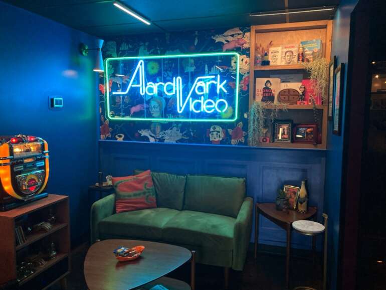 Discover The Secrets Behind the Door of 'I Like It Like That', Grandview's Newest Bar 3 bar interior with green couch and neon lights