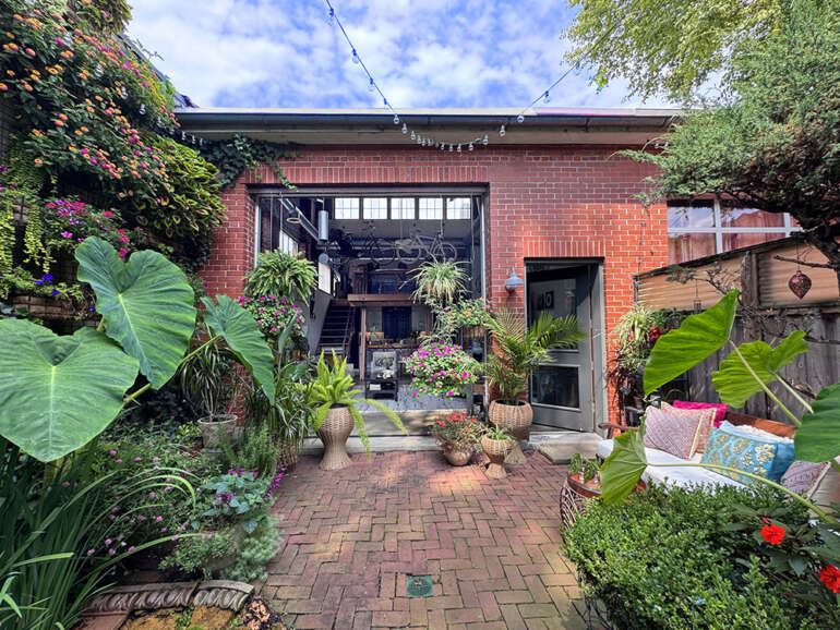 small brick home with lush garden