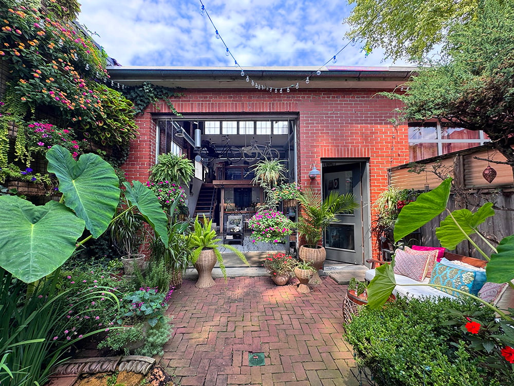 small brick home with lush garden