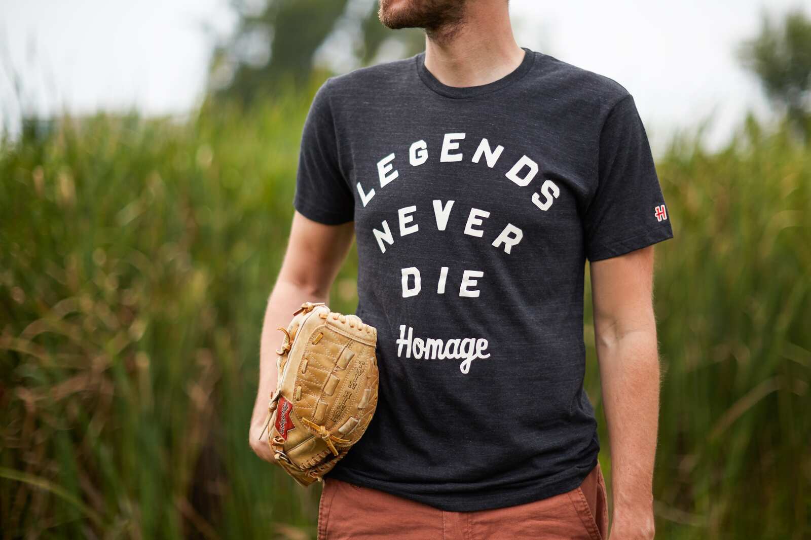 man wearing homage t-shirt in field