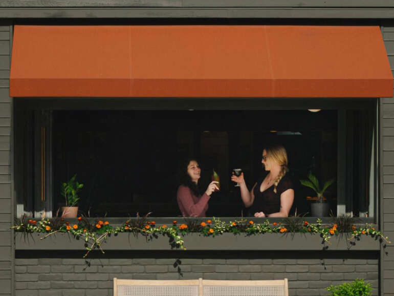 This Italian Village Spot Is Finally Reopening After A Car Crashed Into The Restaurant 3 people drinking at restaurant