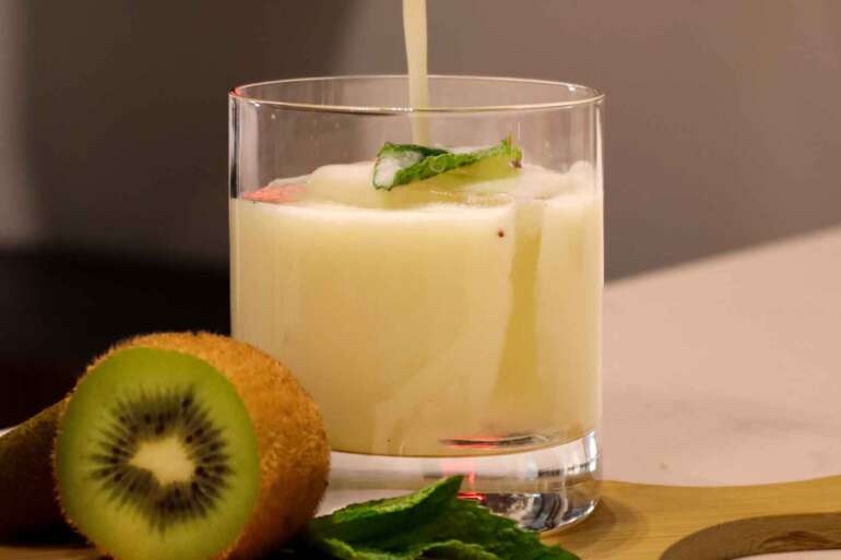 a mixed drink being poured into glass