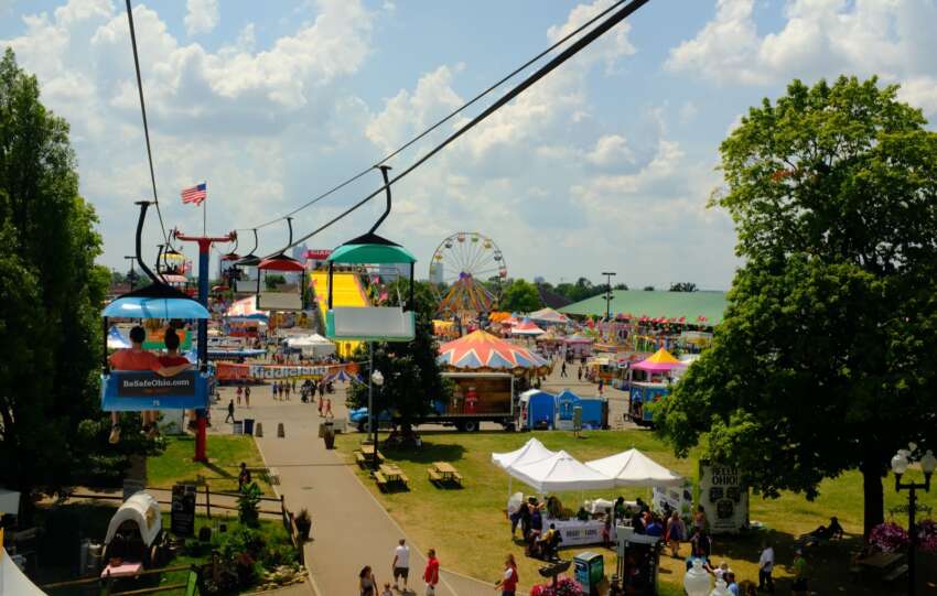 The Ohio State Fair Ferris wheel, giant slide, and midway rides seen from the SkyGlider over the fairgrounds