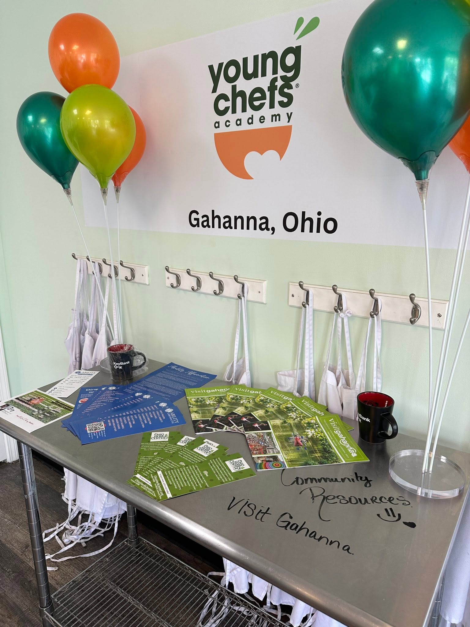 young chef's academy booth at festival with aprons and balloons