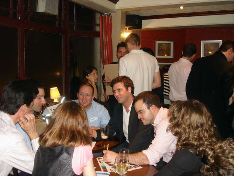 Trivia teams gathered around a pub table during a quiz night