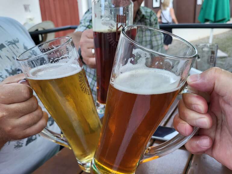 Three beer glasses raised in a toast