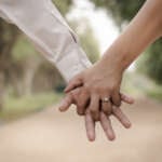 An engaged couple linking fingers