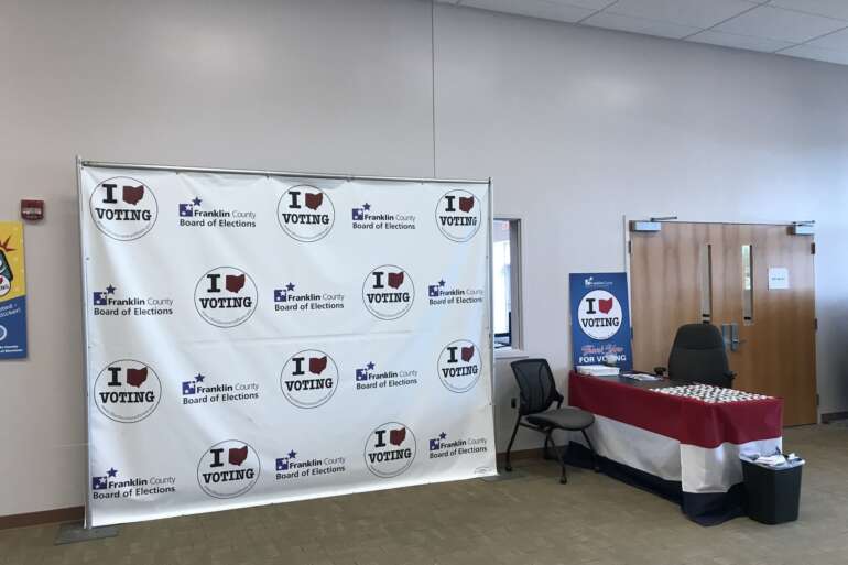 How To Become A Poll Worker In Ohio 1 An I Voting backdrop and a check-in table inside the Franklin County Board of Elections