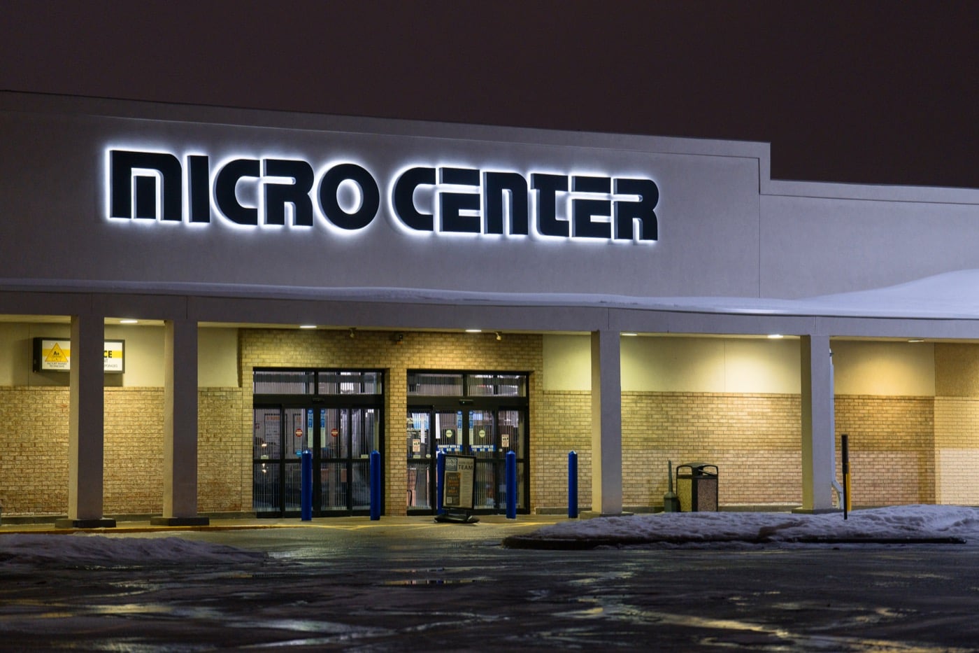 Glowing Micro Center sign above a storefront at night