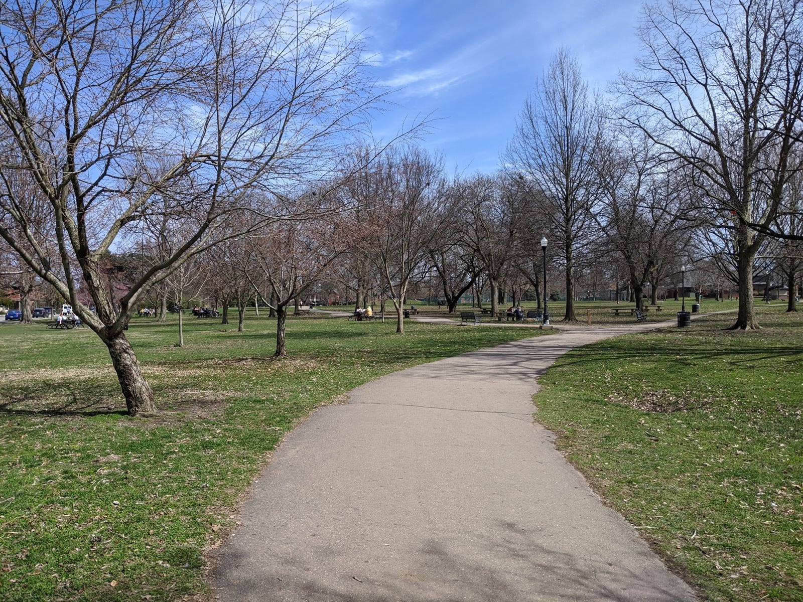 Paved path curving through the lawn and trees of Schiller Park in German Village