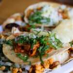 Columbus Taco Fest Left Downtown For Obetz And Went 21+ Tacos al pastor topped with chopped onion and cilantro on a plate